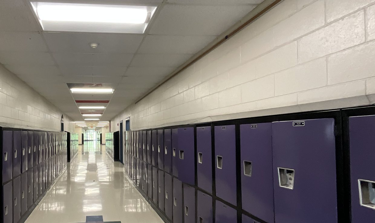 Chester Academy hallway with purple lockers under LED troffers, Chester, NH