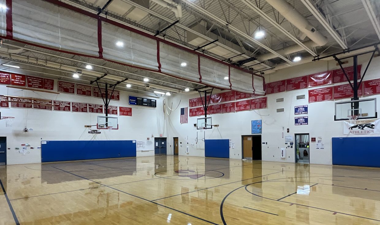 Empty Chester Academy gymnasium under round LED high-bay fixtures, Chester, NH