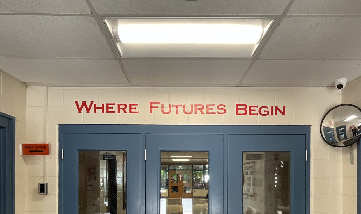Chester Academy entrance under an LED ceiling panel, with Where Futures Begin lettered above the doors, Chester, NH