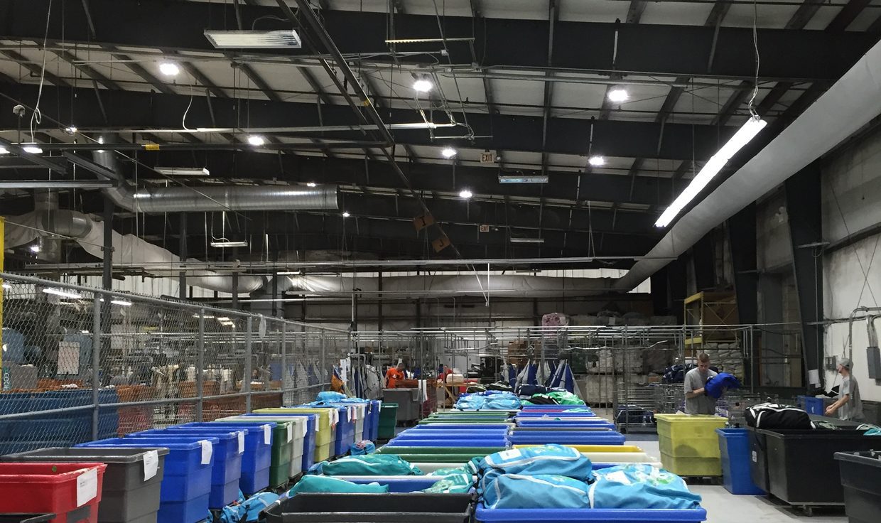 Rows of laundry carts on the E&R Cleaners sorting floor under LED high-bay fixtures, Manchester, NH