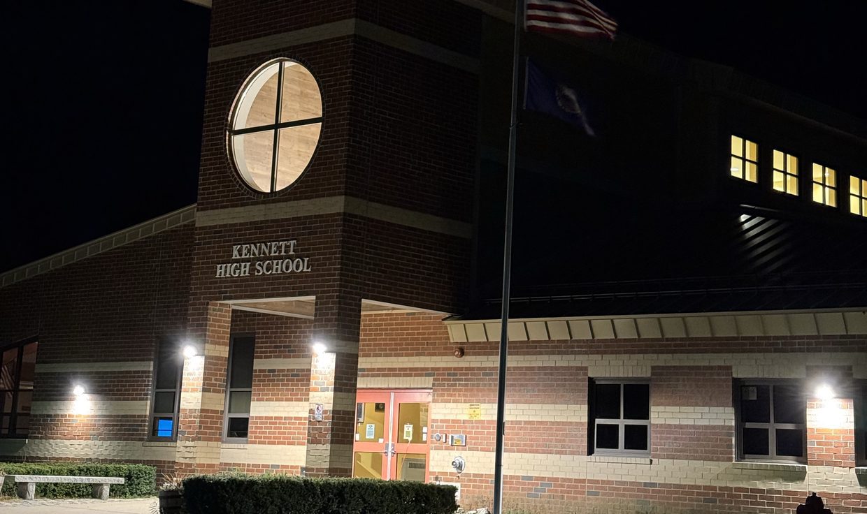 Kennett High School entrance at night with lit wall-mounted fixtures, Conway, NH