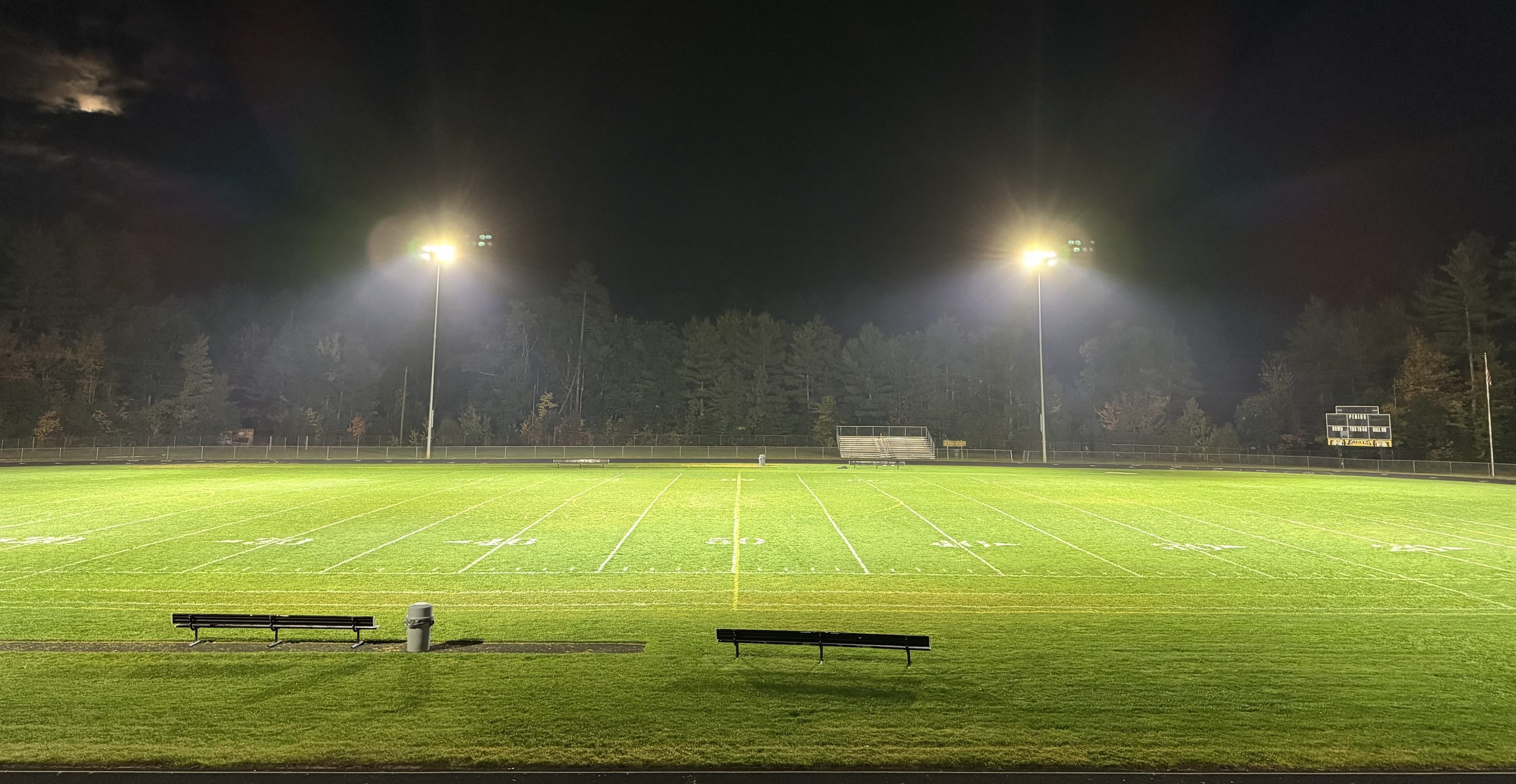 Kennett High School football field evenly lit by two LED light poles at night, Conway, NH