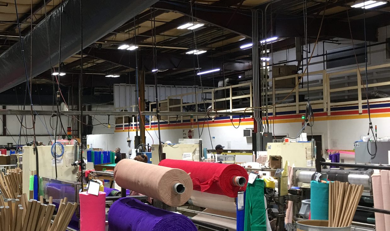Rolls of colored material on the Milliken Healthcare converting floor under LED high-bay fixtures, Salisbury, MA