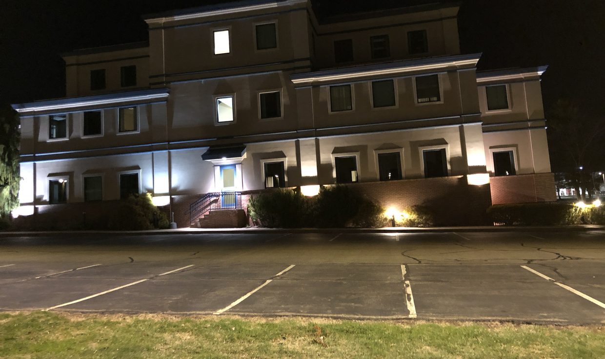 Office building at One New Hampshire Avenue at night, with exterior lights over its parking lot, Pease Tradeport, Portsmouth, NH