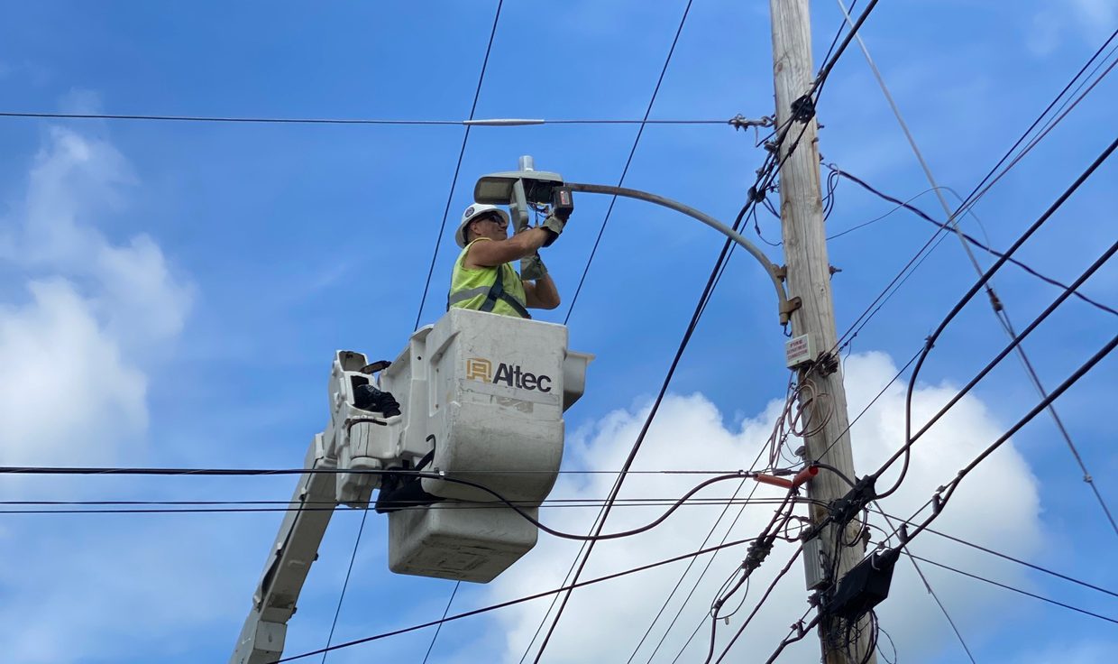 Lineworker in a bucket truck installing a streetlight on a utility pole, Bristol, NH